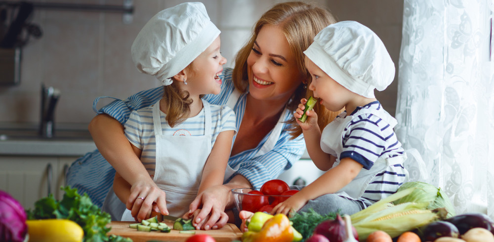 Healthy eating. Happy family mother and children  prepares   vegetable salad in kitchen