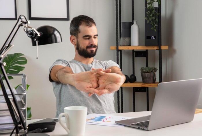 man-stretching-his-arms-while-working-from-home-pq