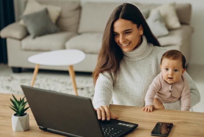pq-mother-with-baby-daughter-working-computer-from-home