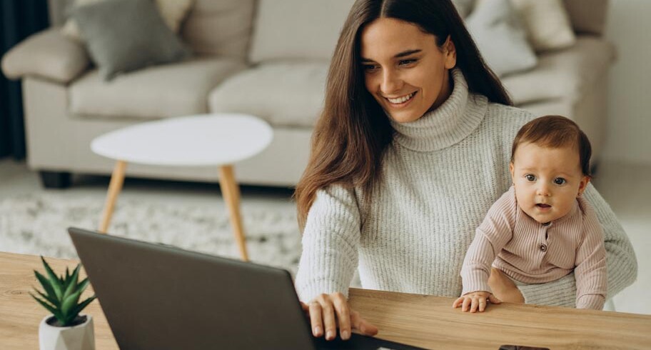 pq-mother-with-baby-daughter-working-computer-from-home
