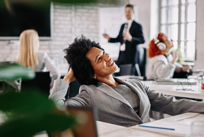 happy-african-american-businesswoman-taking-break-from-work-day-dreaming-office-there-are-people-background-pq